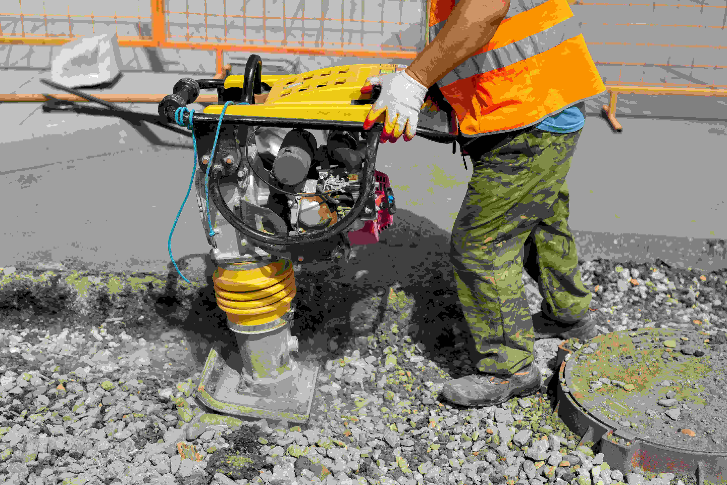 Portable vibration rammer to compact asphalt during paving work, representing professional paving services in Roswell