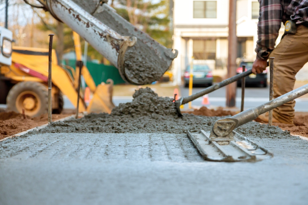Workers installing new concrete curbs on a street as part of professional concrete installation services.